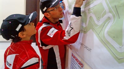 A young Rashid Al Dhaheri studies the racing line with his then French trainer Paul Chatenay. Photo: Al Dhaheri family