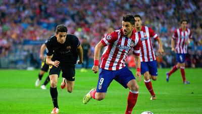 David Villa, right, of Atletico Madrid gets a step on Barcelona’s Marc Bartra during their Uefa Champions League game on Wednesday night. G Moreno / Getty Images