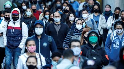 People protected with face masks walk in the southern area of Sao Paulo, Brazil. EPA
