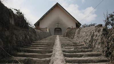 A church is covered by the ashes from Mount Sinabung eruptions in Kuta Rakyat, North Sumatra, Indonesia, Wednesday, Feb. 5, 2014. The rumbling volcano in western Indonesia unleashed fresh clouds of searing gas, killing more than a dozen of people. Mount Sinabung erupted again Saturday just a day after authorities allowed thousands of villagers who had been evacuated to return to its slopes, saying volcanice activity was decreasing. Binsar Bakkar / AP Photo