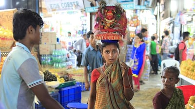A girl asks for donations in lieu of blessings from the Hindu goddess from visitors at the Crawford Market. Subhash Sharma for The National
