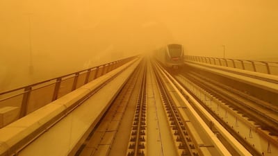 A Dubai metro train is seen driving as the skies turn orange in Dubai. AFP