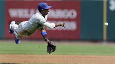 Los Angeles Dodgers second baseman Dee Gordon tosses to first base in a failed attempt to throw out St. Louis Cardinals’ Kolten Wong during the first inning of a baseball game in St. Louis. Jeff Roberson / AP