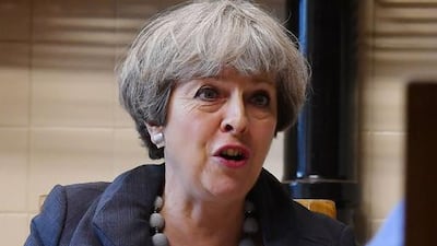 British Prime Minister Theresa May speaks to the Done family during an election campaign visit to their farm in near Overton, north-east Wales. Ben Stansall / AFP