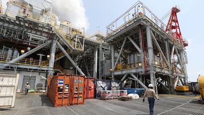 Oil workers walk across the deck of the Agbami floating production, storage and offloading vessel in the Agbami deepwater oilfield in the Niger Delta, Nigeria. George Osodi / Bloomberg
