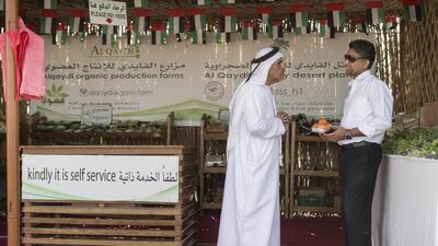 The kiosk was started by Emirati farmer Abdullah Al Qaydi and works on an honesty concept where customers check the price and place the money in a locked box. Brother Salem Al Qaydi speaks to customer Firoz Pallpurayil Majeed from Kalba while he shops. Antonie Robertson / The National