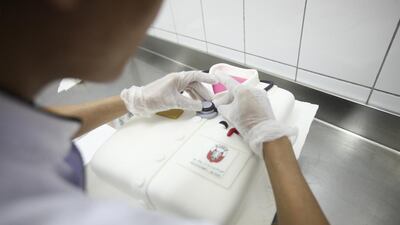 Seen here is Paul Salas, from Miss J Cafe, putting the final touches on a cake in the shape of a doctor’s smock. Lee Hoagland / The National