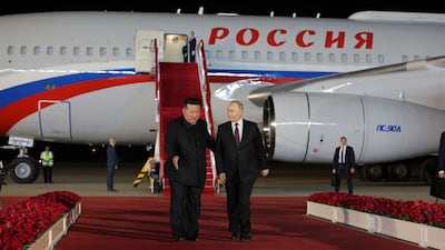 Mr Putin is welcomed by Mr Kim as he disembarks. Korean Central News Agency / Reuters