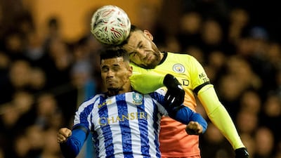 Shefield Wednesday's Jacob Murphy and Nicolas Otamendi of Manchester City challenge for a header. EPA