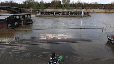 An electric bicycle ploughs through flooded docks on the banks of the Seine river in Paris. AFP