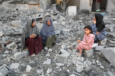 Palestinians sit on rubble at the site of an Israeli strike on a house, in Jabalia, northern Gaza, on Thursday. Reuters