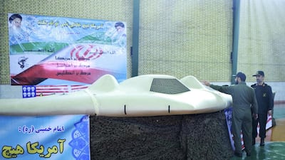 An undated picture shows a member of Iran's revolutionary guard pointing at the US RQ-170 unmanned spy plane at an unknown location in Iran. Sepah News.ir/ Handout/Reuters