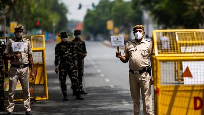 Policemen guard a roadblock in New Delhi on April 20, 2021, as India locked down its capital for a week beginning April 19 seeking to control a raging coronavirus outbreak. AFP