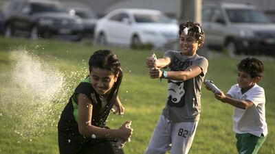 Young boys spray each other with foam and silly string in Abu Dhabi. Silvia Razgova / The National