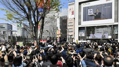 People gather to watch a huge screen broadcasting live reports on the unveiling of the new era name. Reuters