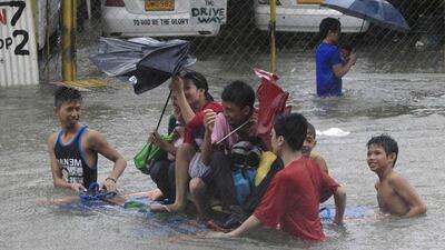 Stranded passengers ride on improvised wooden floaters to cross a flooded street after tropical storm Fung-Wong battered Metro Manila. Romeo Ranoco / Reuters