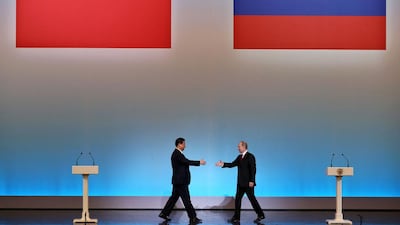 China’s President Xi Jinping, left, is welcomed by his Russian counterpart Vladimir Putin during an opening ceremony of “The Year of Chinese Tourism in Russia” in Moscow in 2013. Sergei Ilnitsky / AFP photo