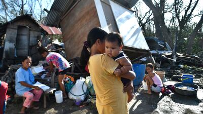 People gather next to their destroyed home in Carcar. AFP