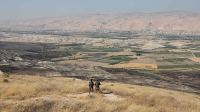 In this file photo taken on June 23, 2019 Israeli soldiers stand guard in an old army outpost overlooking the Jordan Valley. AFP