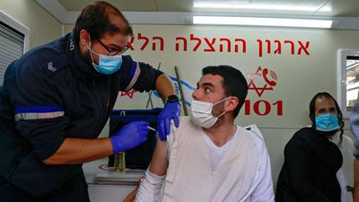 A paramedic administers a dose of the Pfizer/BioNTech coronavirus vaccine to an Israeli man inside a mobile clinic of Magen David Adom at the Mahane Yehuda Market in Jerusalem. Israel's inoculation campaign is regarded as the world's fastest, with one dose of the Pfizer/BioNTech vaccine administered to 4.25 million people out of its nine million-strong population since December, according to the latest health ministry figures. AFP
