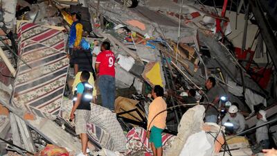 People stand near a collapsed building in Manta. Paul Ochoa / Reuters