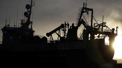 The sun sets behind vessels and cranes in the harbour in Reykjavik, Iceland. Matt Cardy / Getty Images