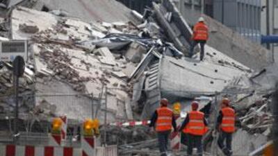 Members of emergency services search for people feared trapped underneath the rubble of the collapsed archive in Cologne.