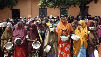 Women and children await food aid in Mogadishu in 2014. But this help comes at a cost, as Angus Deaton writes: “Aid undermines the contract between government and the governed that is essential for successful development.” Abdurashid Abdulle / AFP