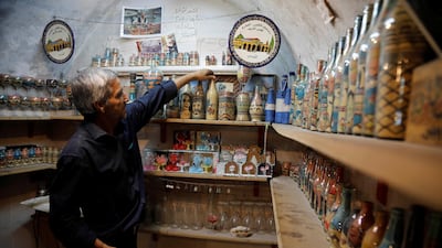 Al-Awawda arranges artworks at his shop. Reuters
