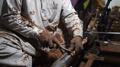 An artisan works on a machine to make components used in bagpipes. AFP.