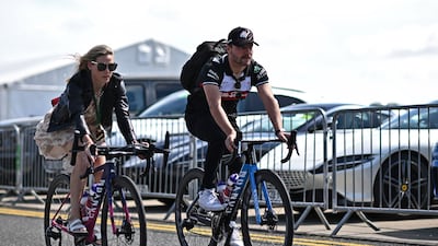 Alfa Romeo's Finnish driver Valtteri Bottas and his partner, cyclist Tiffany Cromwell, arrive on their bikes. AFP