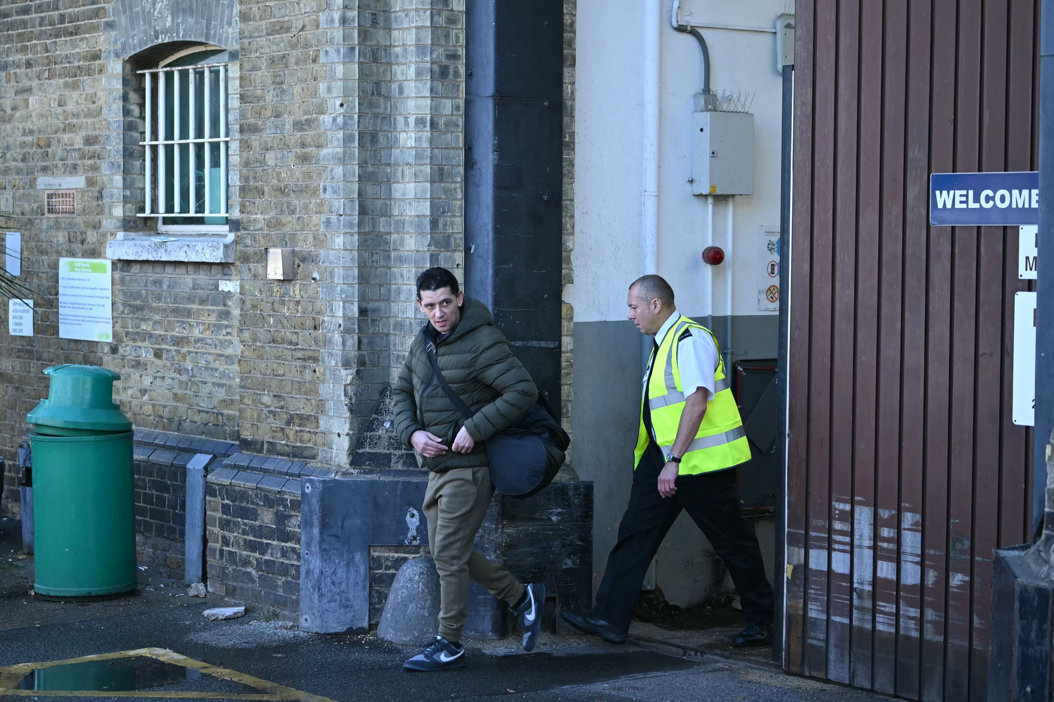 A released prisoner (L) leaves Brixton prison in south London on October 13, 2026, during the second phase of a scheme to free up prison places. (Photo by JUSTIN TALLIS / AFP)