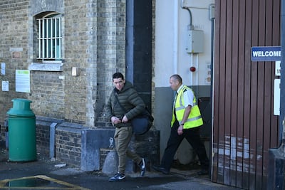 A released prisoner (L) leaves Brixton prison in south London on October 13, 2026, during the second phase of a scheme to free up prison places. (Photo by JUSTIN TALLIS / AFP)