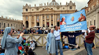 Pilgrims pose for a photo in front of St Peter's Basilica in Vatican City on April 26, 2014, a day before the historic double canonisation of Pope John Paul II and Pope John XXIII. Radek Pietruszka / EPA