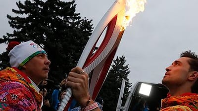 Boxer Kostya Tszyu, left, and singer Dima Bilan with Olympic torches in Moscow. Dmitry Lovetsky / AP Photo