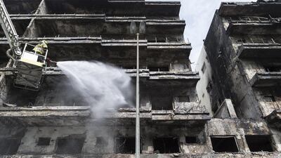 Dubai Civil Defense douse the burnt Deira apartment building.