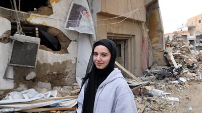 A woman stands next to destroyed buildings in the southern town of Qana. AFP