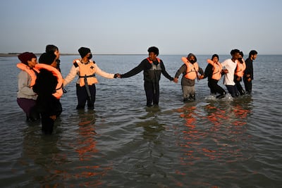Migrants wait to board an inflatable dinghy to cross from France to England. Reuters