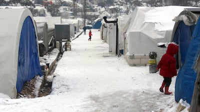 Syrian walking outside their tents at a displaced people camp near Turkish border, in Idlib province, Syria. AP