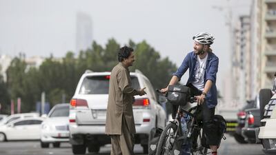 Australian cyclist Aaron Austin-Glen makes friends with a Pakistani expatriate during a stopover in Abu Dhabi, while he waits for his visa to India. Silvia Razgova / The National