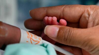 Diana Paola Angola who recovered of the novel coronavirus, COVID-19, caress her son Jefferson at the neonatal room in the Versalles Clinic, in Cali, Colombia. AFP