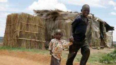 Children walk past a makeshift house at a slum in Hatcliffe, Harare. Some 800 people have died of cholera in Zimbabwe in the past four months and the epidemic could spiral out of control, health officials fear.