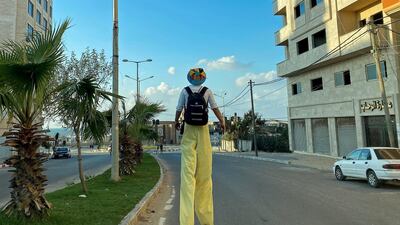 A Palestinian clown on stilts walks on a street amid the pandemic, in Gaza City. Reuters