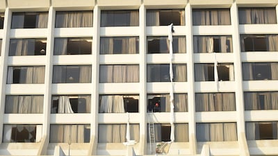 Pakistani fire fighters look from a room of Regent Plaza Hotel. At least two Pakistani international cricketers were staying at the hotel – Sohaib Maqsood and Hammad Azam – though they were not believed to be seriously injured. AFP