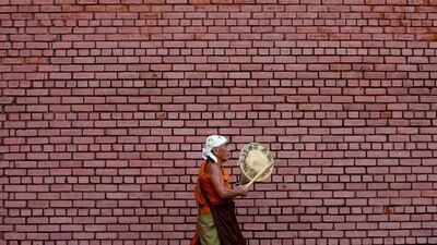 A monk taps a drum as he walks down a street in Colombo, Sri Lanka. Dinuka Liyanawatte / Reuters