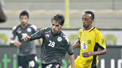 Al Dhafra's Adel Almehrazi keeps control of the ball from Al Wasl's Faisal Khalil at the Zabeel Stadium. Jeff Topping/The National