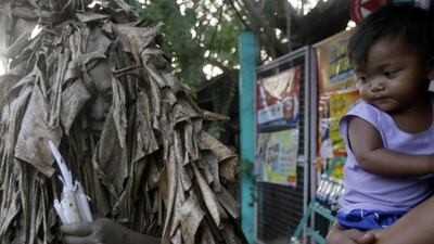 A devotee collects candles. Bullit Marquez / AP Photo