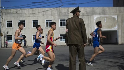 Marathon runners pass by a North Korean soldier during the marathon in Pyongyang in 2013. David Guttenfelder/AP Photo