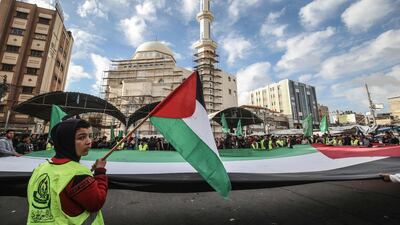 Protesters hold together a giant Palestinian flag during a demonstration against US President Donald Trump's Middle East peace proposal in Khan Yunis in the southern Gaza Strip. AFP