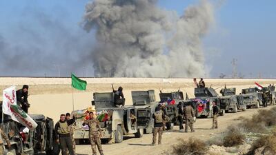Iraqi pro-government forces stand next to armored vehicles as they take position in Al Aramil area, south of Ramadi, during military operations on December 22. AFP Photo